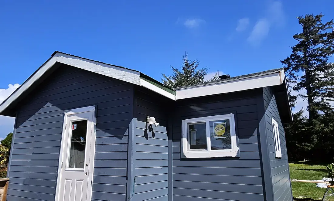Charcoal-sided addition with new trim, windows, and roofline, general construction by SeaBreeze